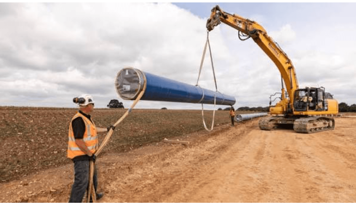 Workers laying large blue water pipe sections for the Grafham Transfer project